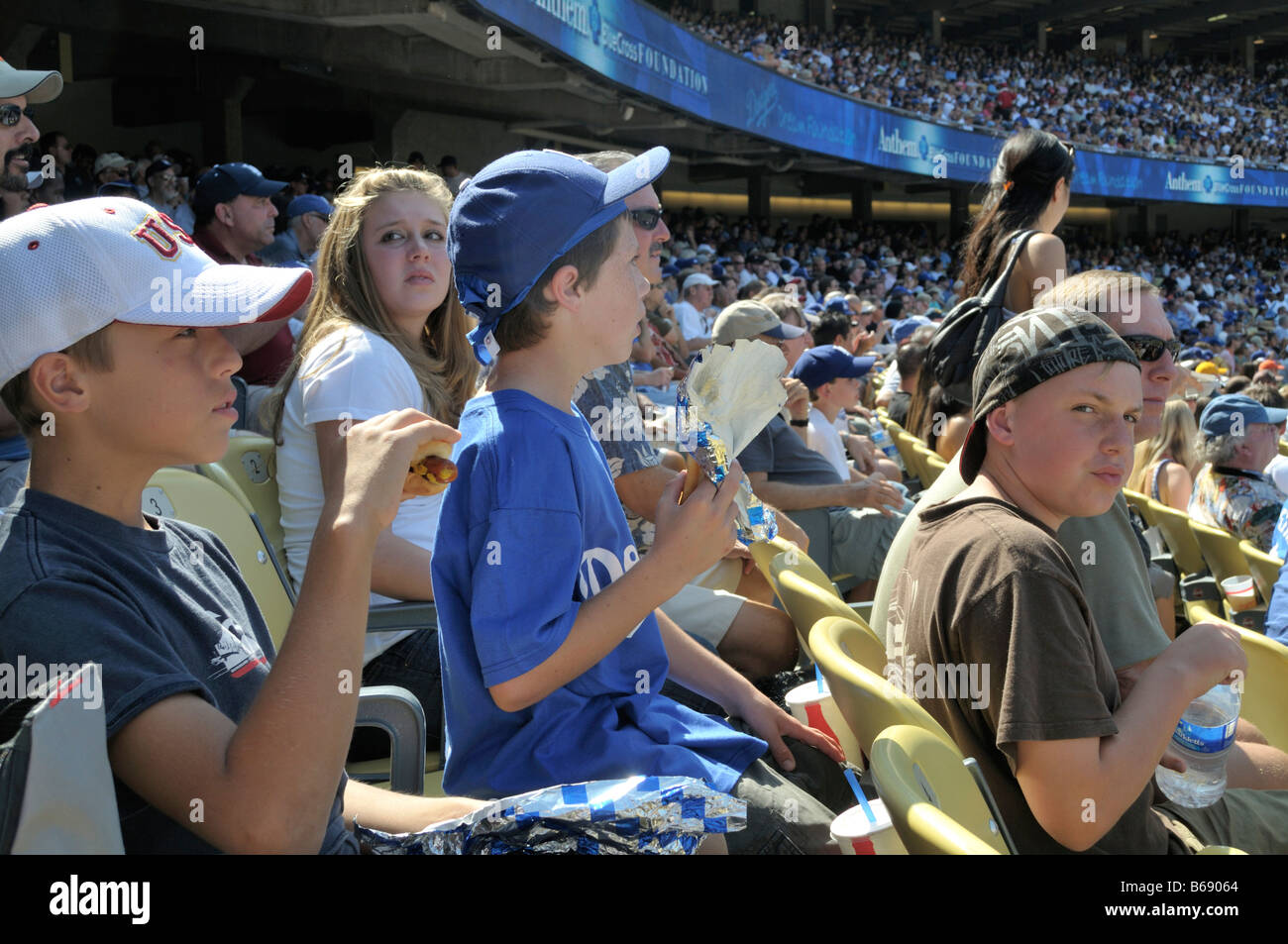 Giovani appassionati di baseball snacking su Dodger cani e whatnot mentre intensamente seguendo il gioco in corso Foto Stock