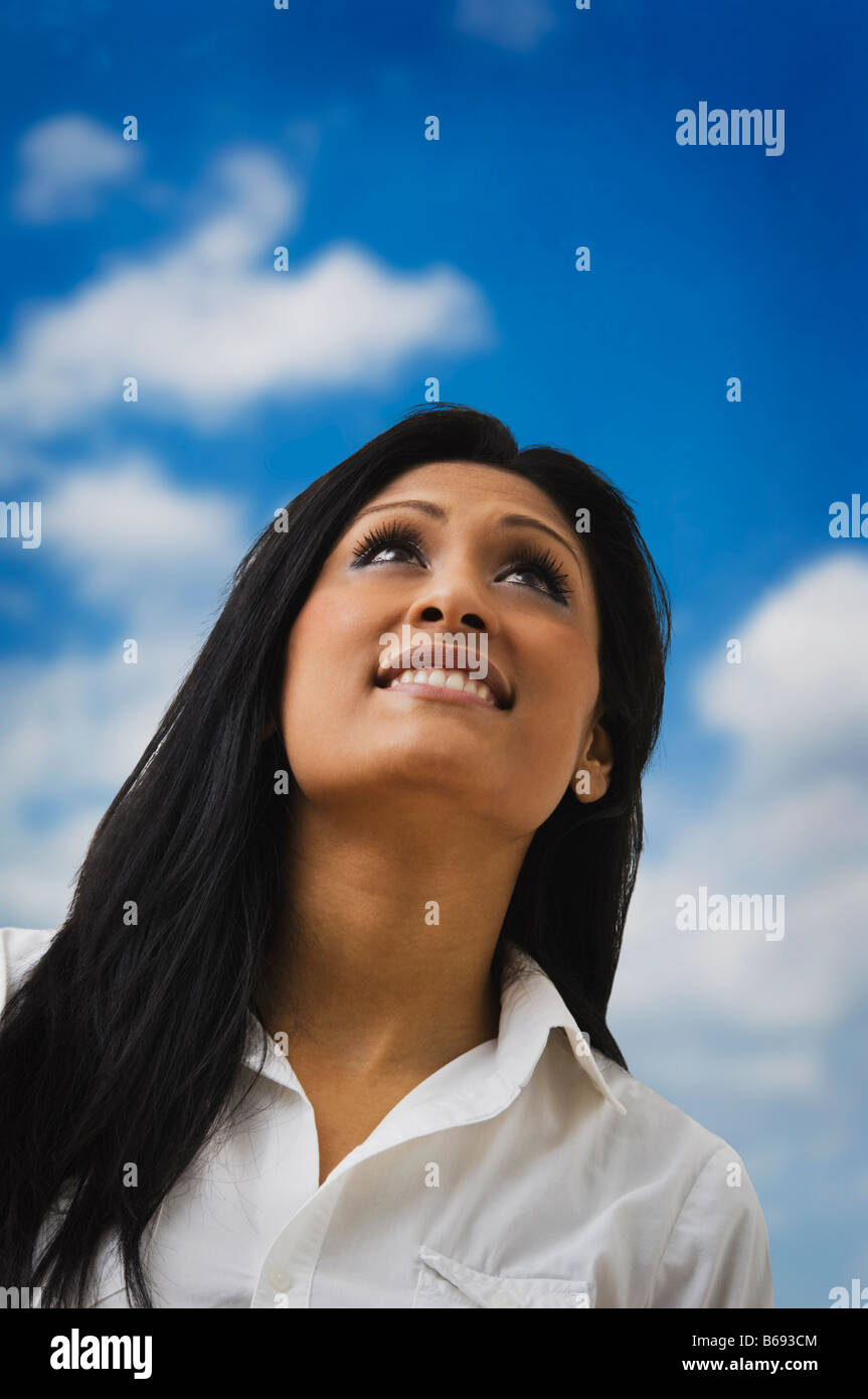 Giovane donna guardando il cielo Foto Stock