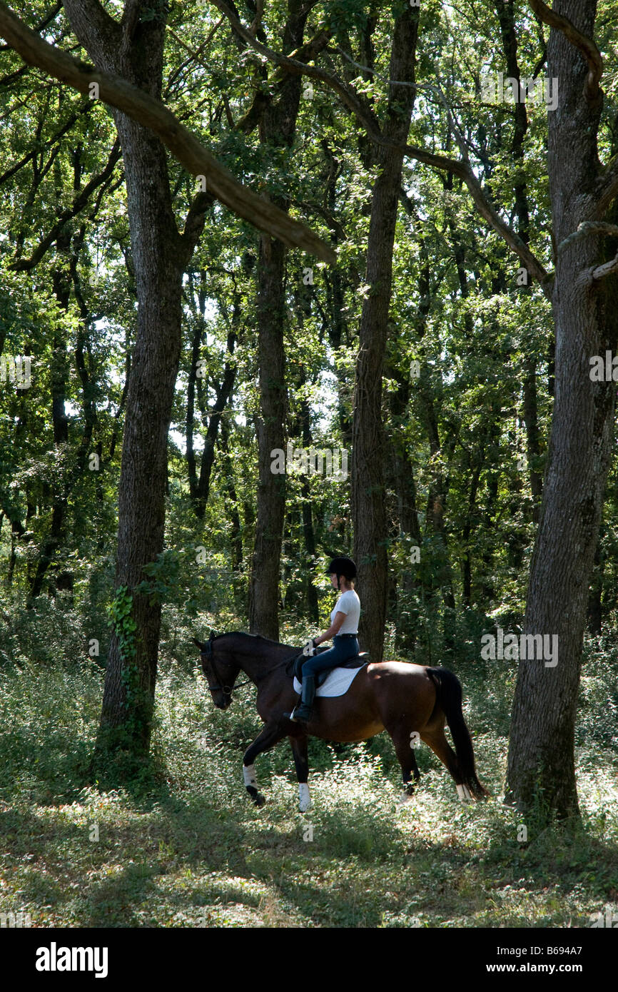 Jill di equitazione di Reynolds nel bosco al suo patrimonio nel sud-ovest della Francia Foto Stock