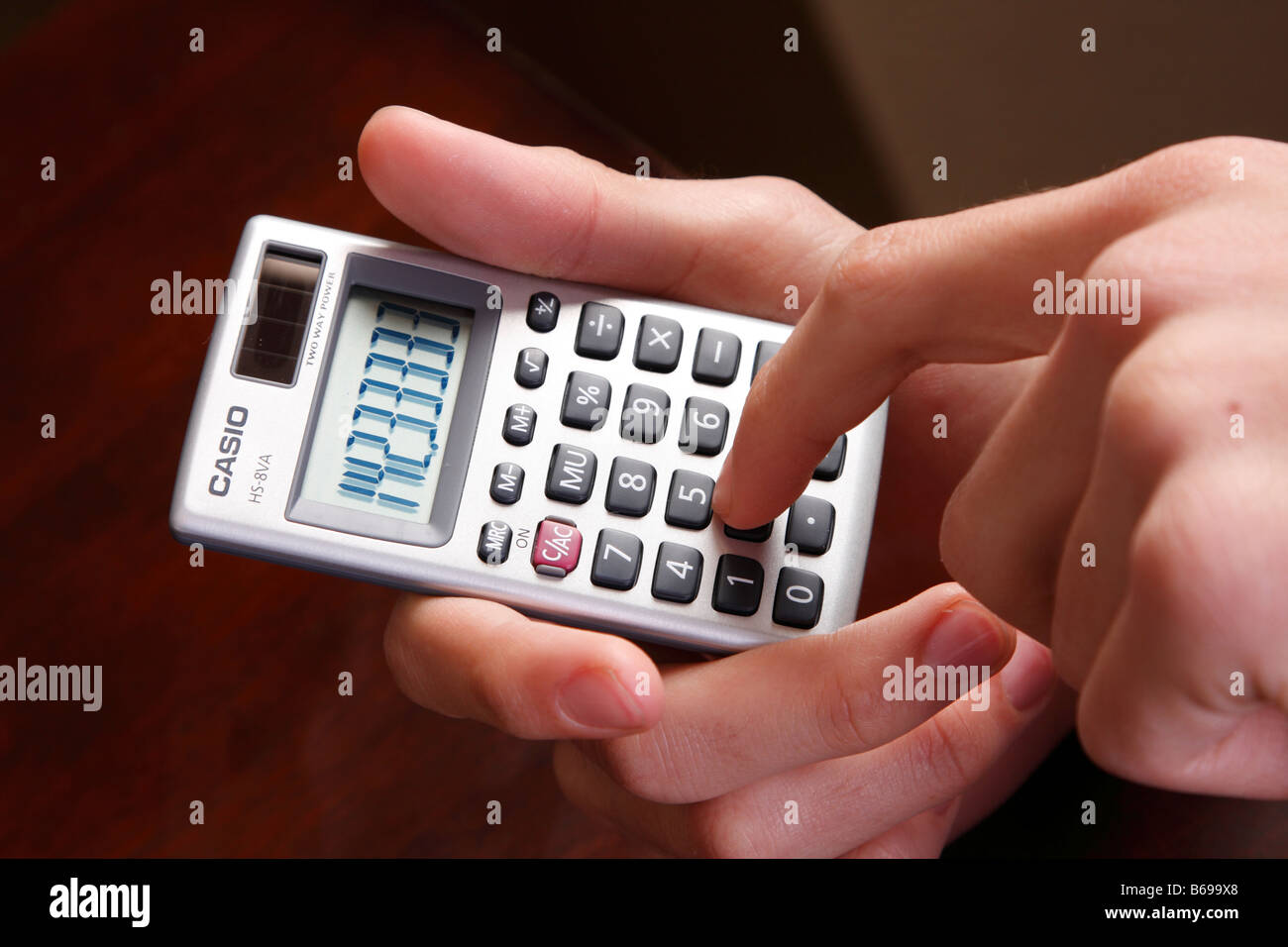 Teen tenendo un solare calcolatrice Foto Stock