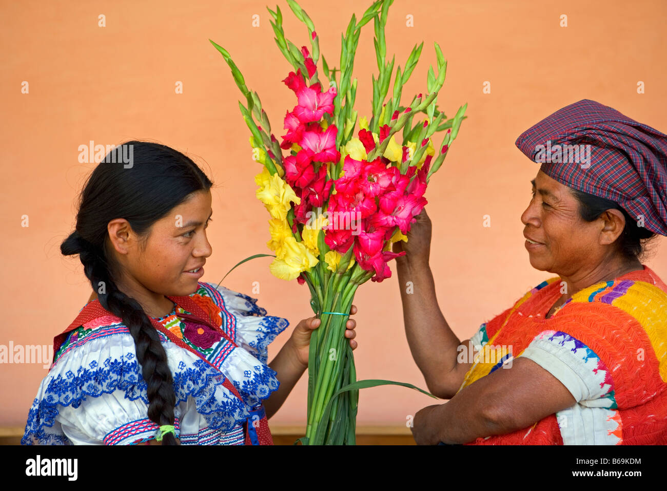 Messico, Chiapas, Amotenango del Valle, due donne di Tzeltal indiani bouquet di contenimento Foto Stock
