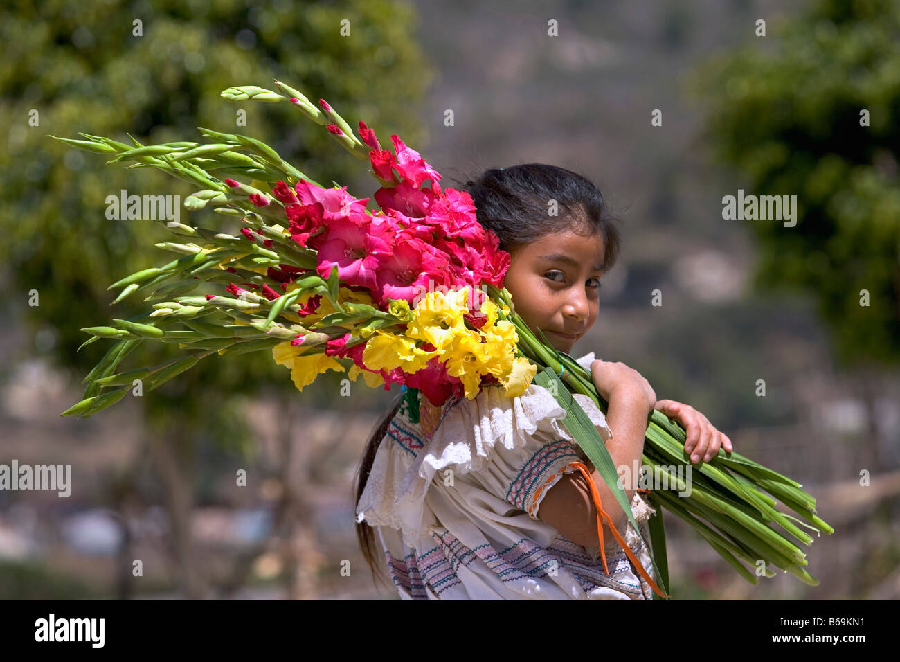 Messico, Chiapas, Amotenango del Valle, donna di Tzeltal indiani bouquet di contenimento Foto Stock