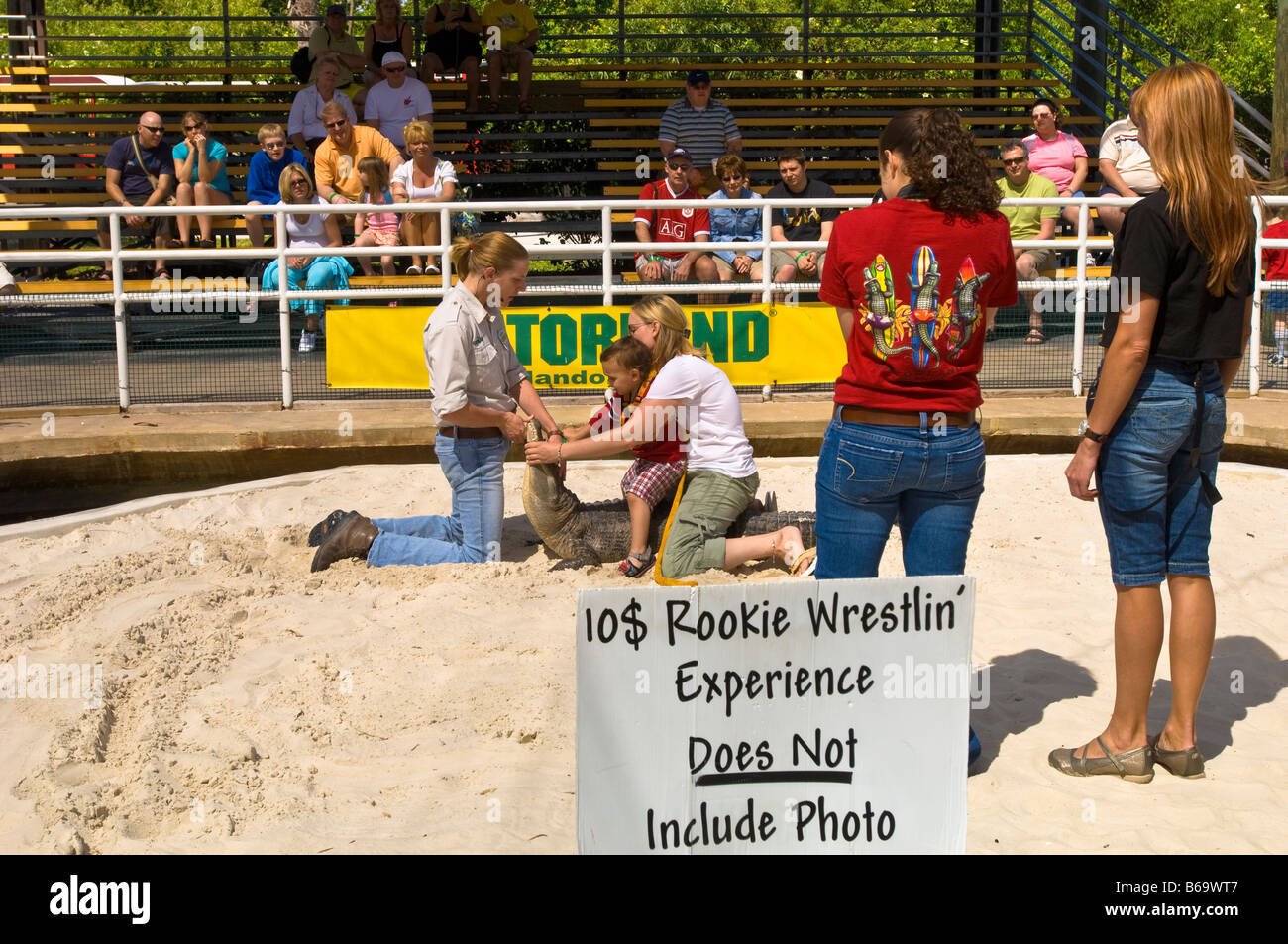 I turisti che posano per una foto durante il wrestling Alligator Spettacolo Gatorland Kissimmee Florida Stati Uniti d'America Foto Stock