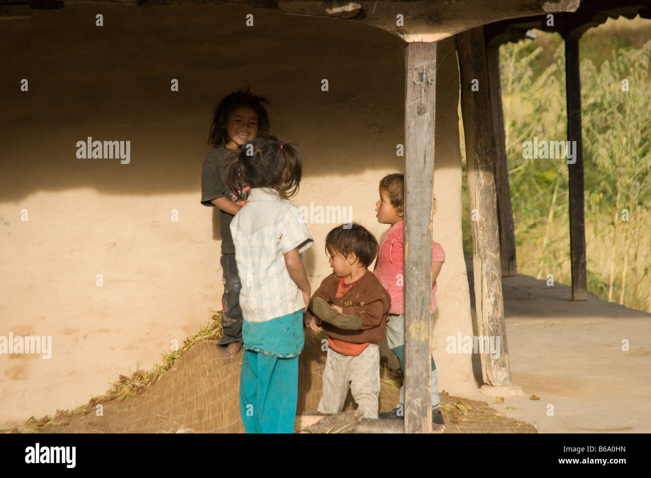 Bambini nepalesi giocando da una casa colonica per il sentiero a Ghandruk nei modi River Valley, Himalaya, Nepal Foto Stock