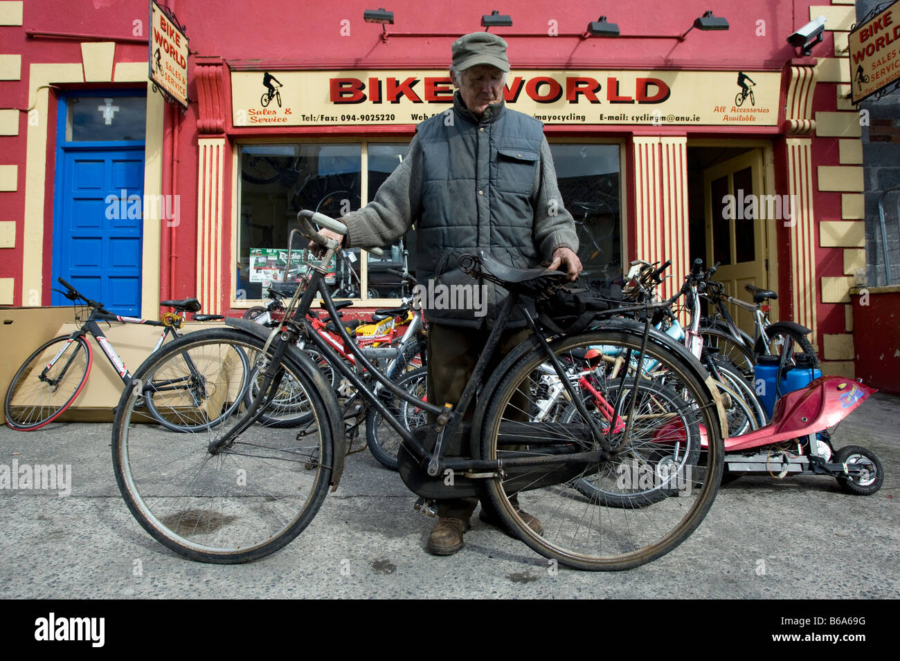 Il vecchio uomo con la sua bicicletta al di fuori di un negozio di  biciclette in un Western Irlanda village Foto stock - Alamy