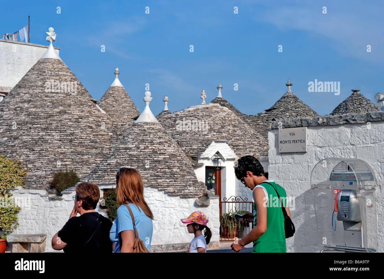 Turisti e distintivo di Trullo case; Alberobello, provincia di Bari Regione Puglia Italia meridionale Foto Stock