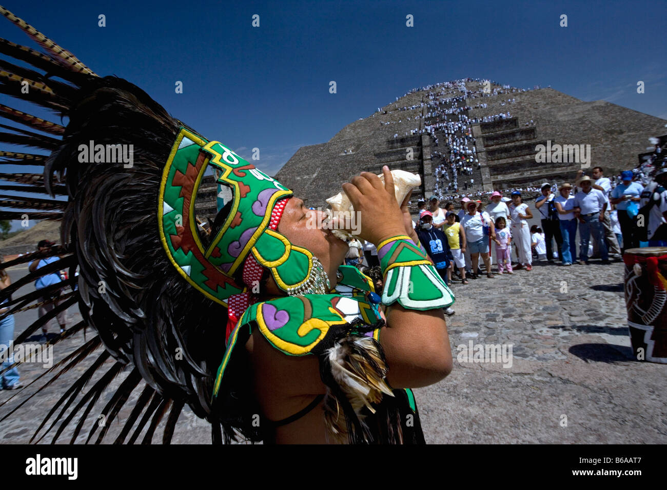 Messico, Teotihuacan, rovine indiane. Equinozio di primavera a molla 21 marzo. Uomo vestito nel tradizionale costume indiano guscio di soffiatura Foto Stock