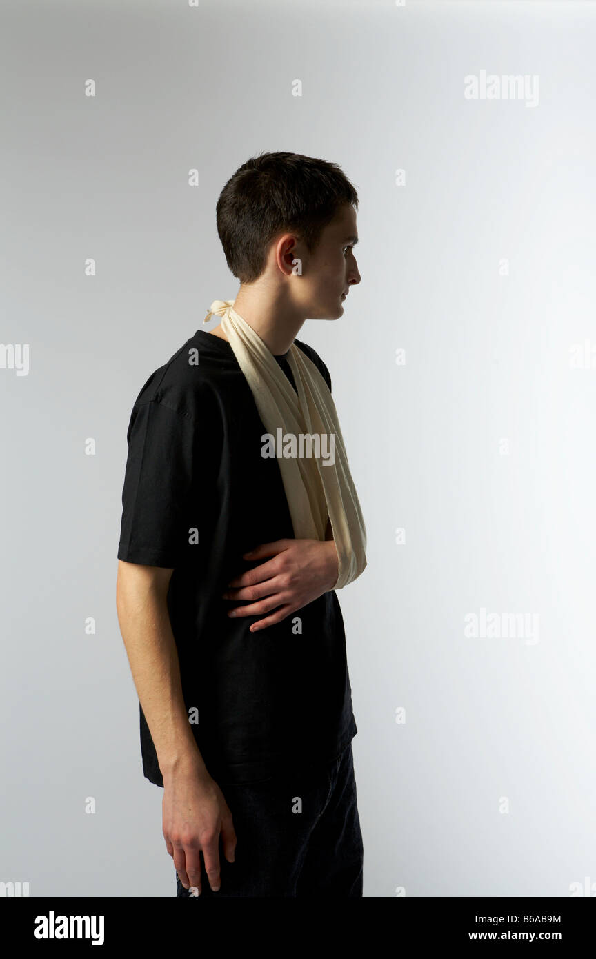 Un adolescente con una fionda sul suo braccio girato in uno studio Foto Stock