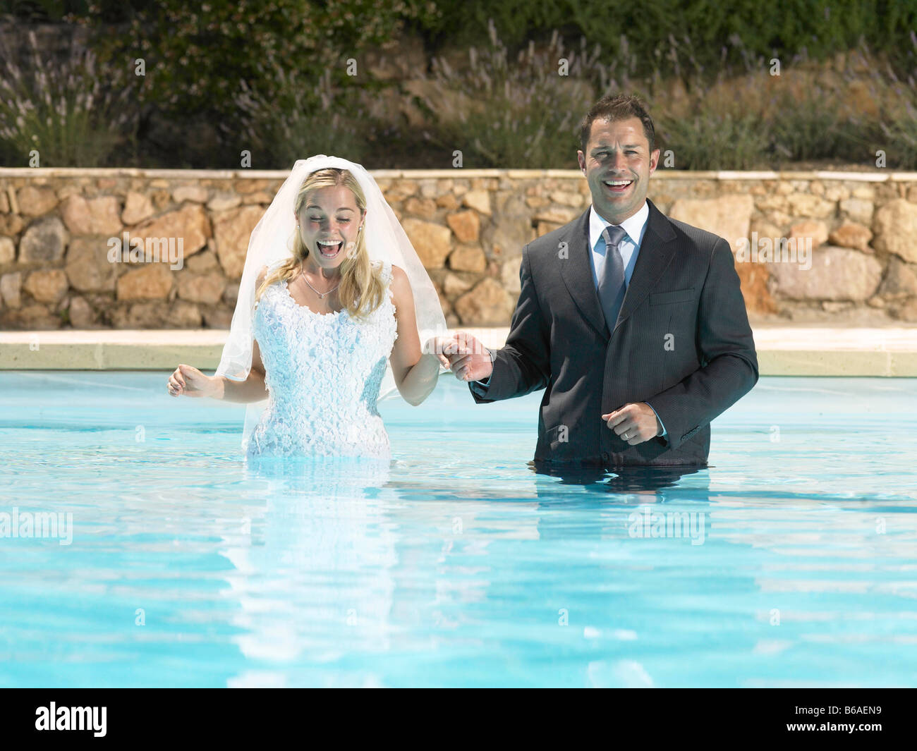 Sposa e lo sposo in piedi in piscina Foto Stock