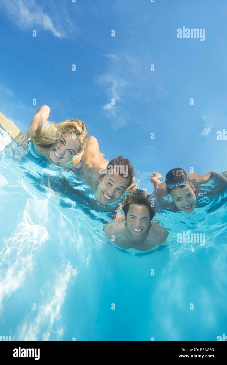 Gruppo di amici immersi in piscina Foto Stock