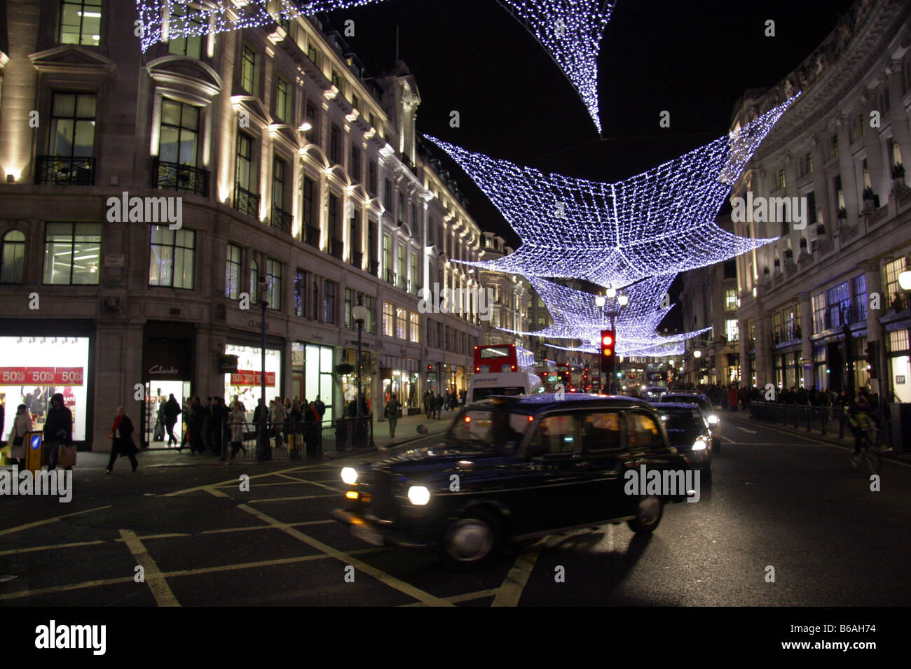 Londra taxi passando sotto le luci di Natale ho Regents Street London REGNO UNITO Foto Stock