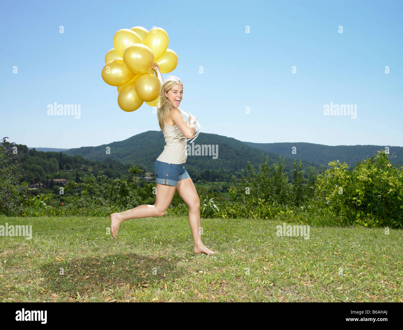 Ragazza che corre con palloncini Foto Stock