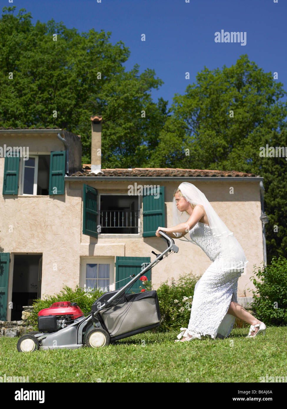 Sposa cercando di falciare il prato Foto Stock