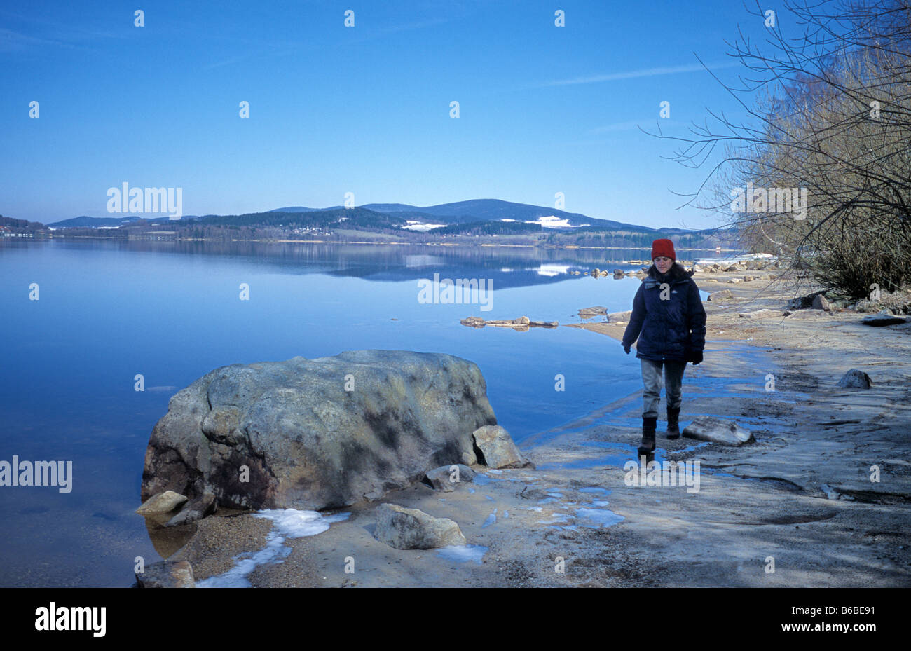 Una donna cammina lungo la riva del lago di Lipno nella Repubblica Ceca Foto Stock