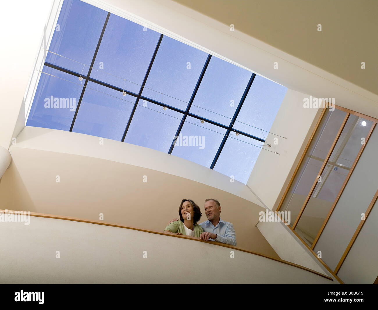 Basso angolo vista del giovane appoggiata contro la parete e sorridente Foto Stock