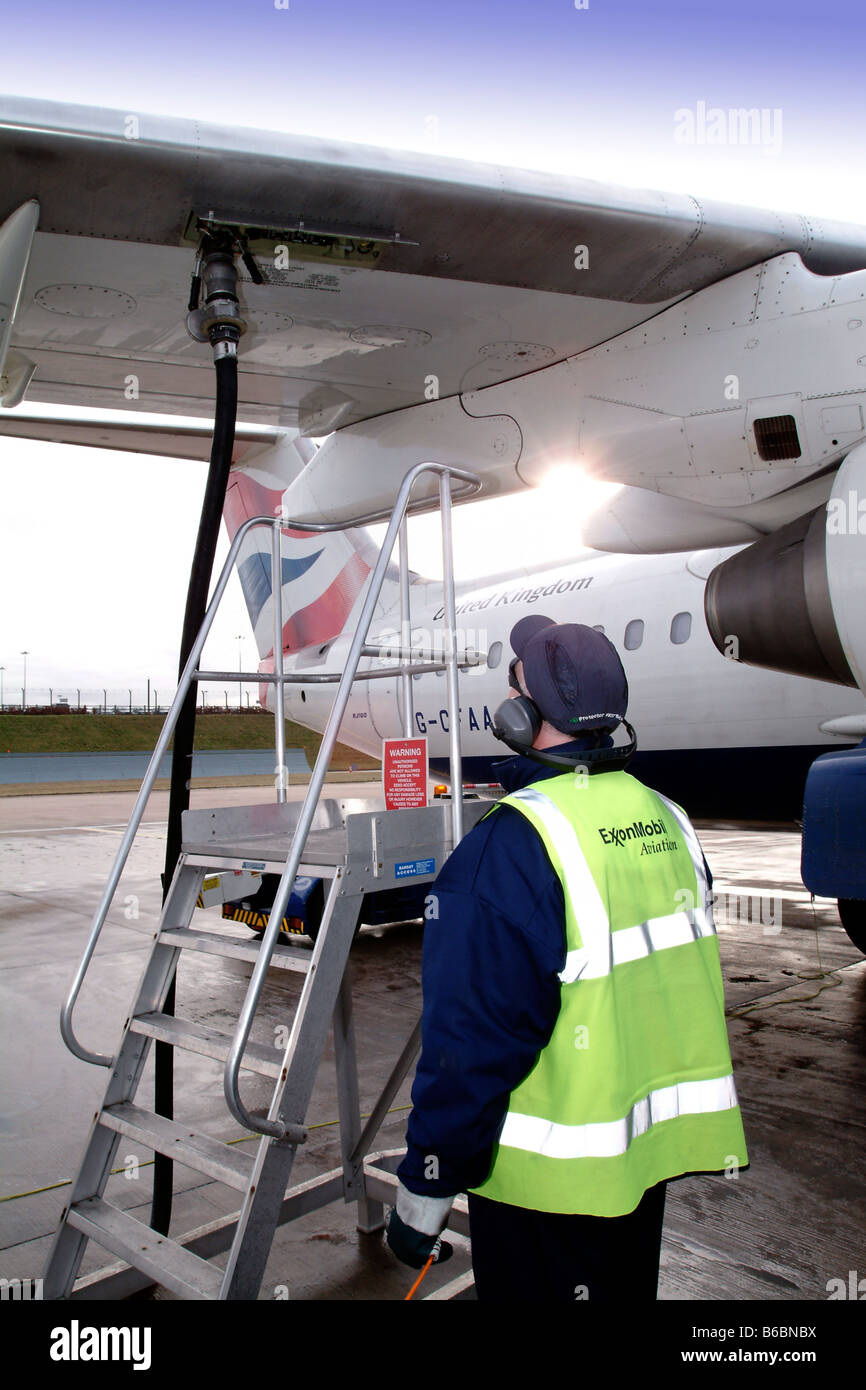 Il tecnico effettua il rifornimento di carburante British Airways BA146 aereo all'Aeroporto di Birmingham Foto Stock