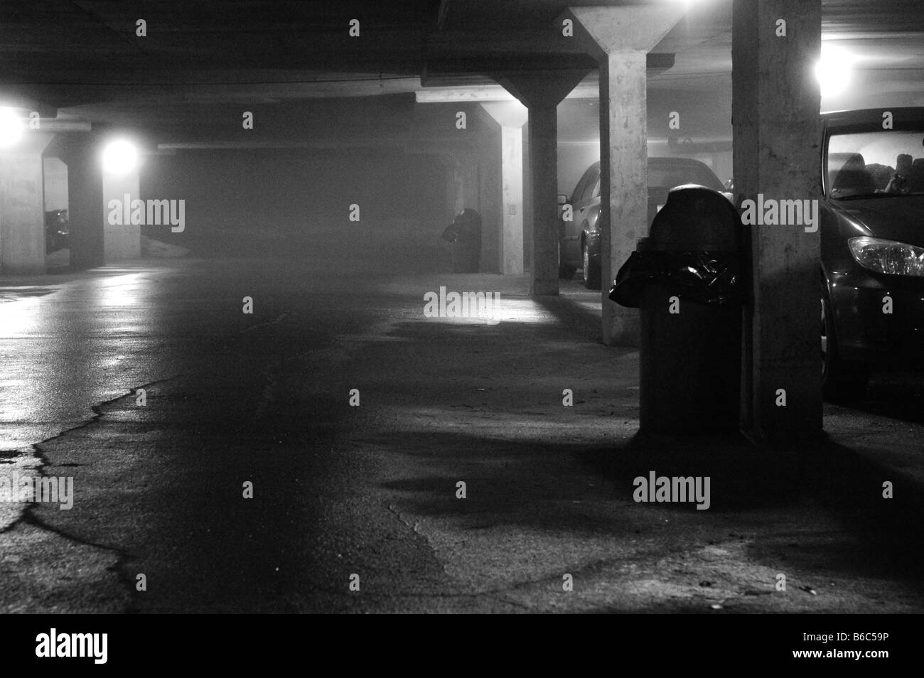 Un lugubre garage per il parcheggio sotterraneo di notte. Foto Stock