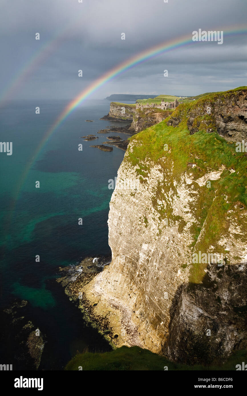 Un arcobaleno doppio sopra le scogliere di rocce bianche e vista verso Dunluce Castle sulla costa North Antrim, Irlanda del Nord Foto Stock