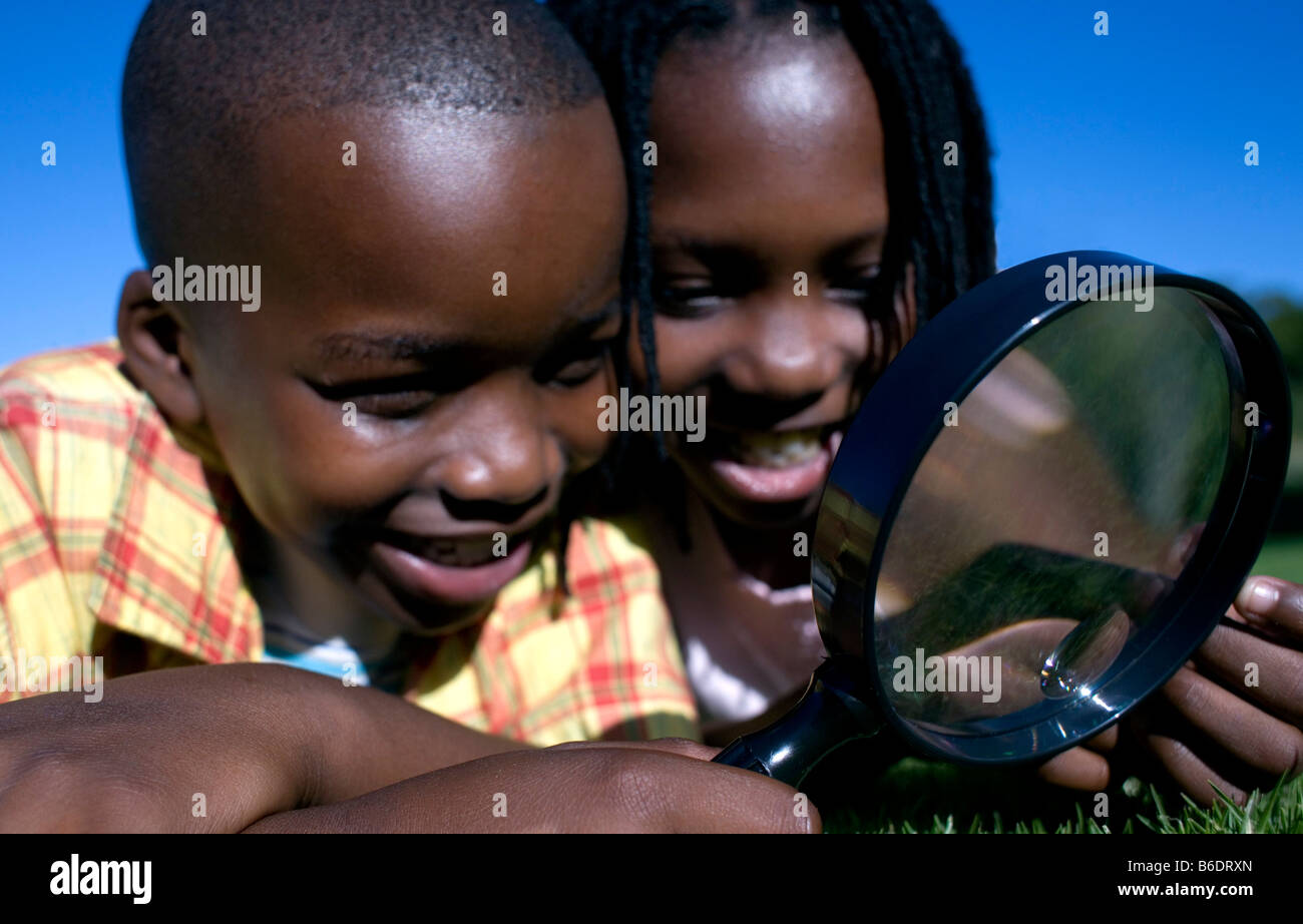 Boy utilizzando una lente di ingrandimento per esaminare un area d erba Foto stock Alamy