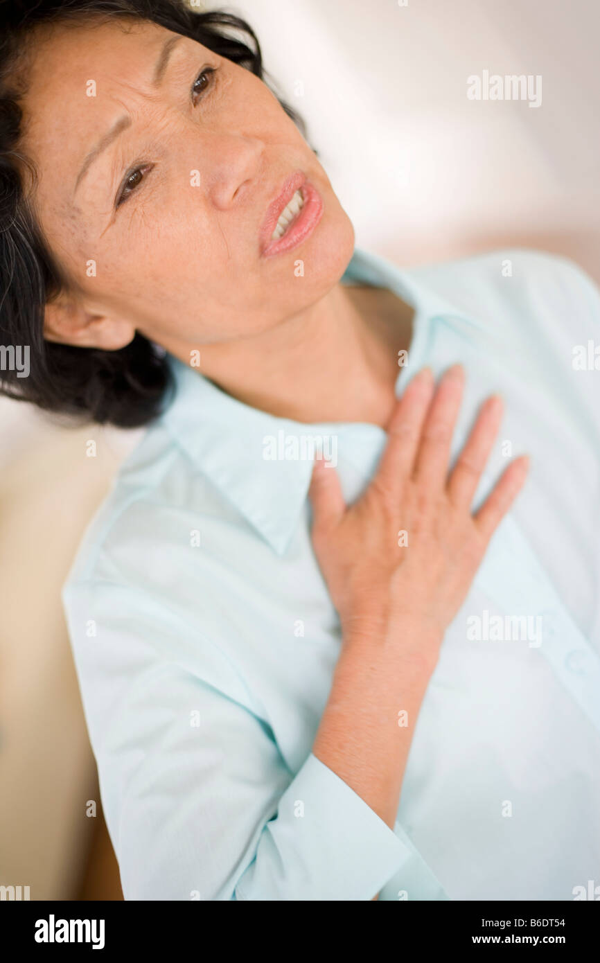 Bruciori di stomaco. La donna che soffre di bruciori di stomaco premendo il suo torace. Foto Stock Bruciori di stomaco. La donna che soffre di bruciori di stomaco premendo il suo torace. Foto Stock