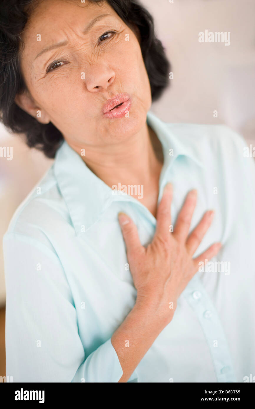 Bruciori di stomaco. La donna che soffre di bruciori di stomaco premendo il suo torace. Foto Stock Bruciori di stomaco. La donna che soffre di bruciori di stomaco premendo il suo torace. Foto Stock