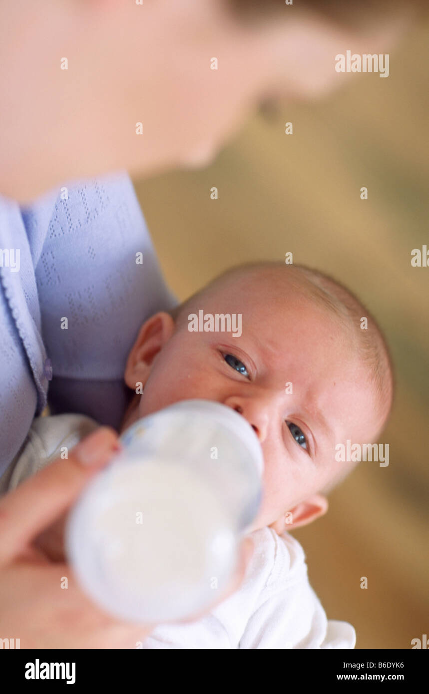 Bottiglia di madre-bambino di alimentazione.Madre utilizzando una bottiglia di alimentazione di latte ai suoi 2 mese-vecchio baby boy. Foto Stock