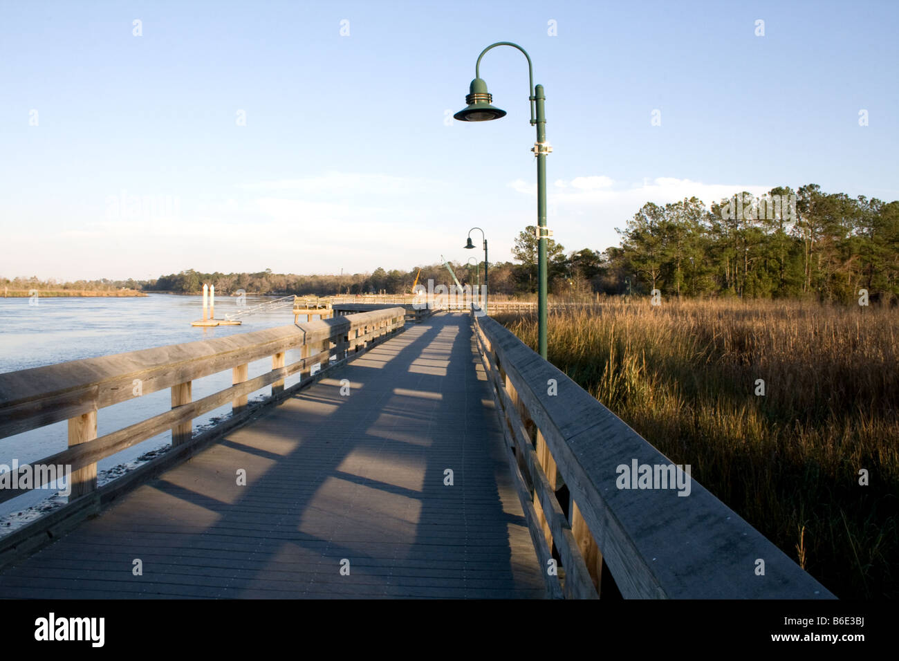 In vecchio stile luce post su un recintato passerella in legno da una palude e un fiume in Woodbine Georgia Foto Stock
