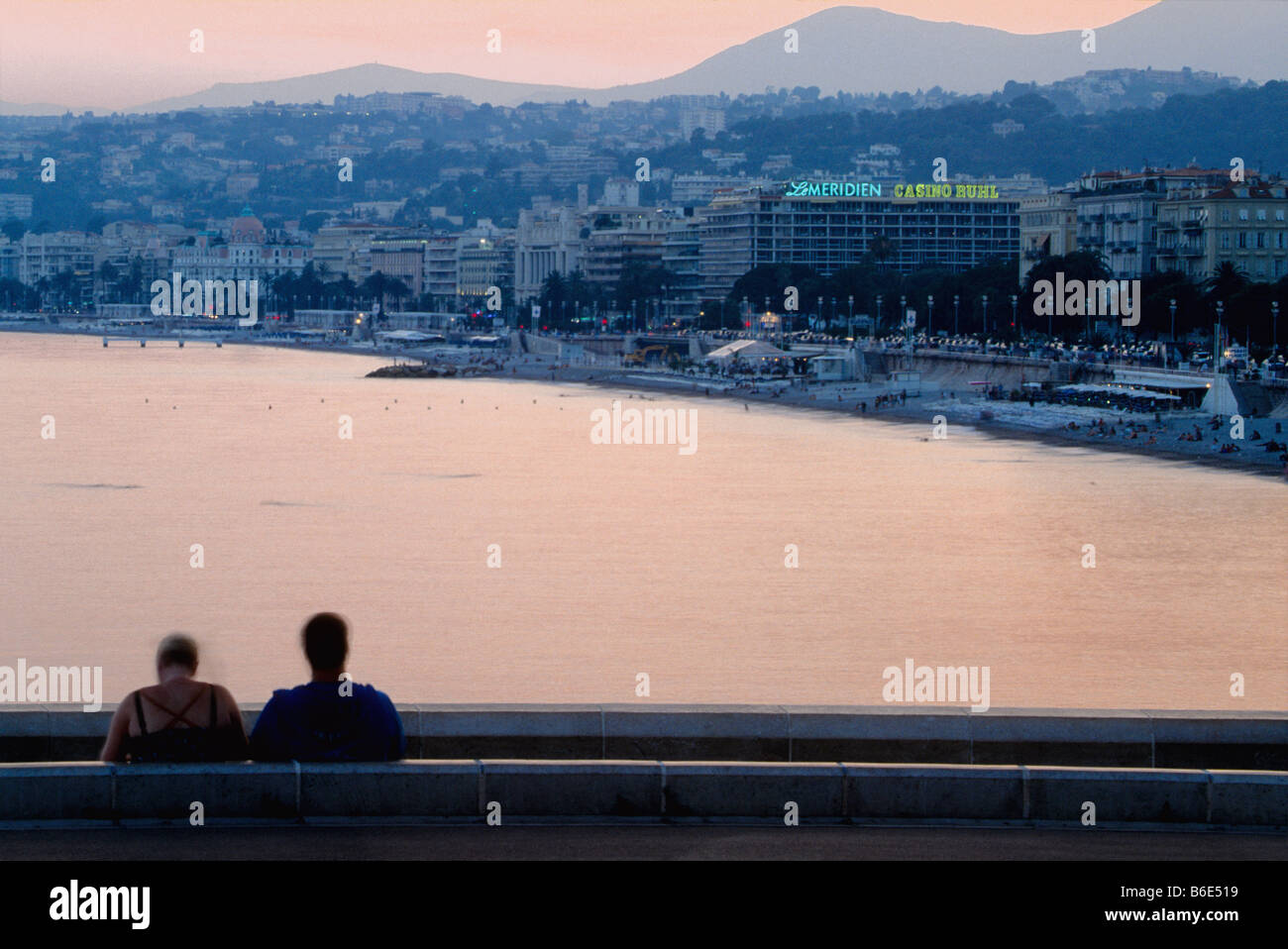 Giovane a guardare il tramonto sopra il mare mediterraneo nella baia di Nizza Foto Stock