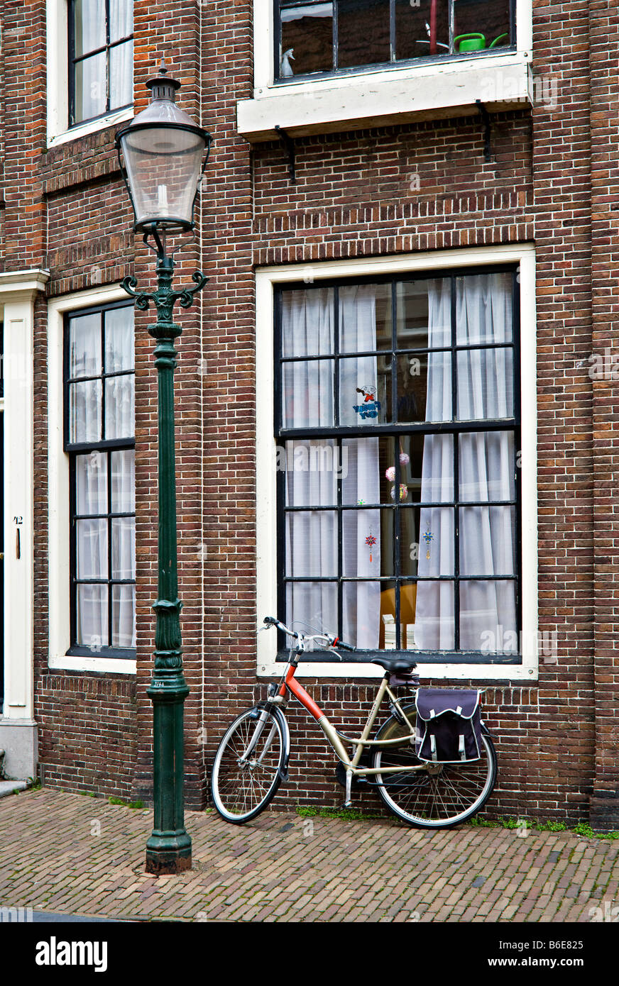 Bicicletta appoggiata contro la finestra di casa con street lampione Enkhuizen Paesi Bassi Foto Stock