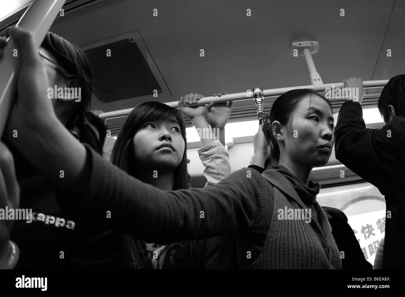 Due le donne cinesi stand pateintly sulla metropolitana affollata nel profondo del pensiero. Chinas crescente popolazione è al momento della nascita: 1.11 maschio(s)/femmina Foto Stock