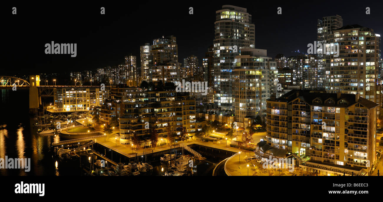 Davie Village Vancouver condomini di notte con False Creek Yacht Club e Burrard Street Bridge Foto Stock