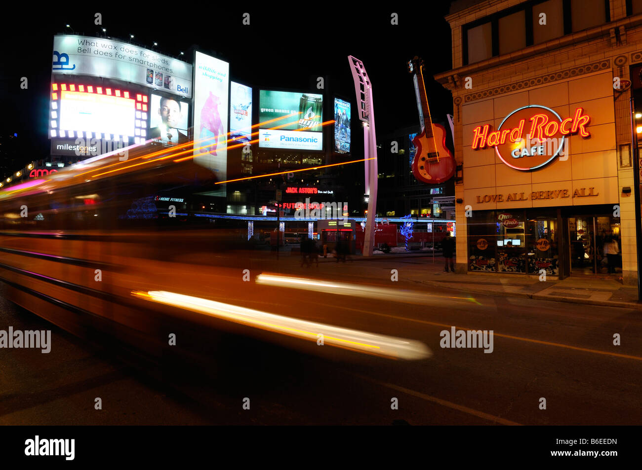 Scuola bus striature di luce di notte con tabelloni luminosi a Dundas Square a Yonge Street Toronto Foto Stock