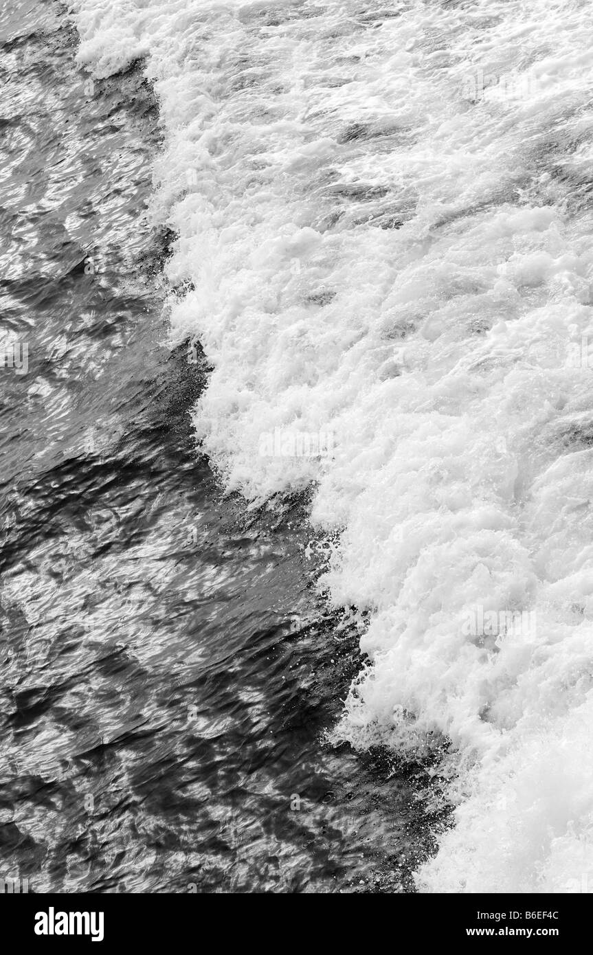 Un ondata di schiantarsi sulla scia di una barca, le acque scure con la zangolatura bianco, del surf e del nuoto in nature palyground Foto Stock