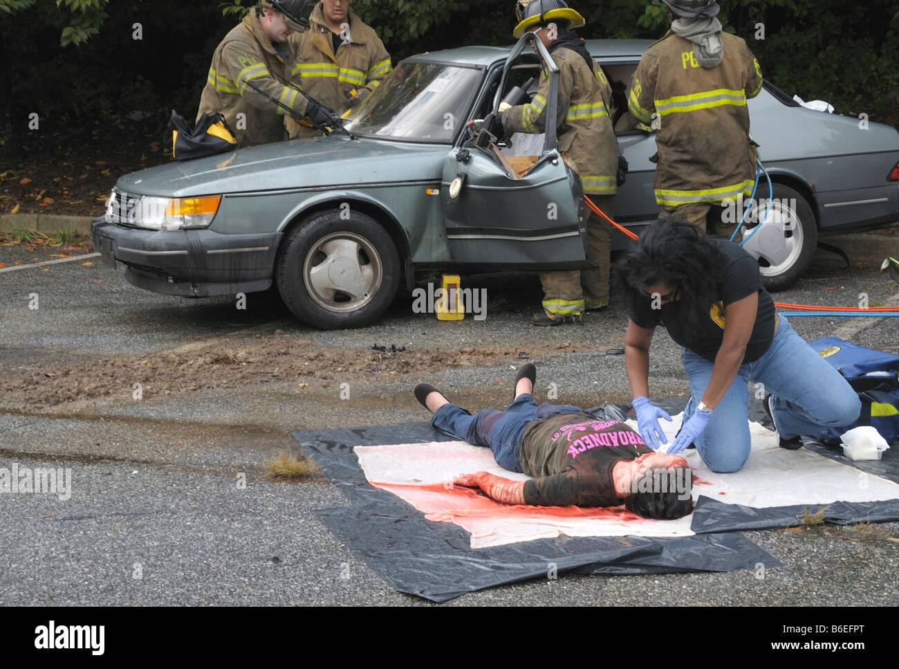 Un medic esamina uno di diverse persone ferite in un incidente automobilistico in Glendale, Maryland Foto Stock
