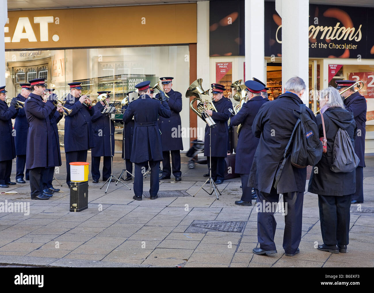 Esercito della salvezza bandsmen, riproduzione di canti natalizi, per raccogliere fondi per il loro appello di Natale, al di fuori di negozi, shoppers, turisti Foto Stock