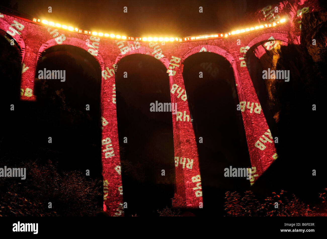 Acqua di irrigazione viadotto illuminato con le lettere "RhB' per celebrare l'accettazione del 'Rhaetische Bahn Ferrovia Albula/essere Foto Stock