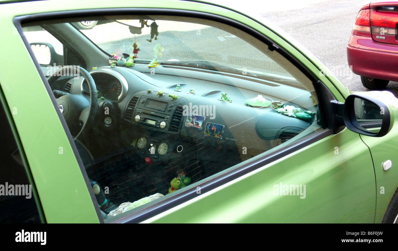 Verde auto con con molte rane sul cruscotto Foto Stock