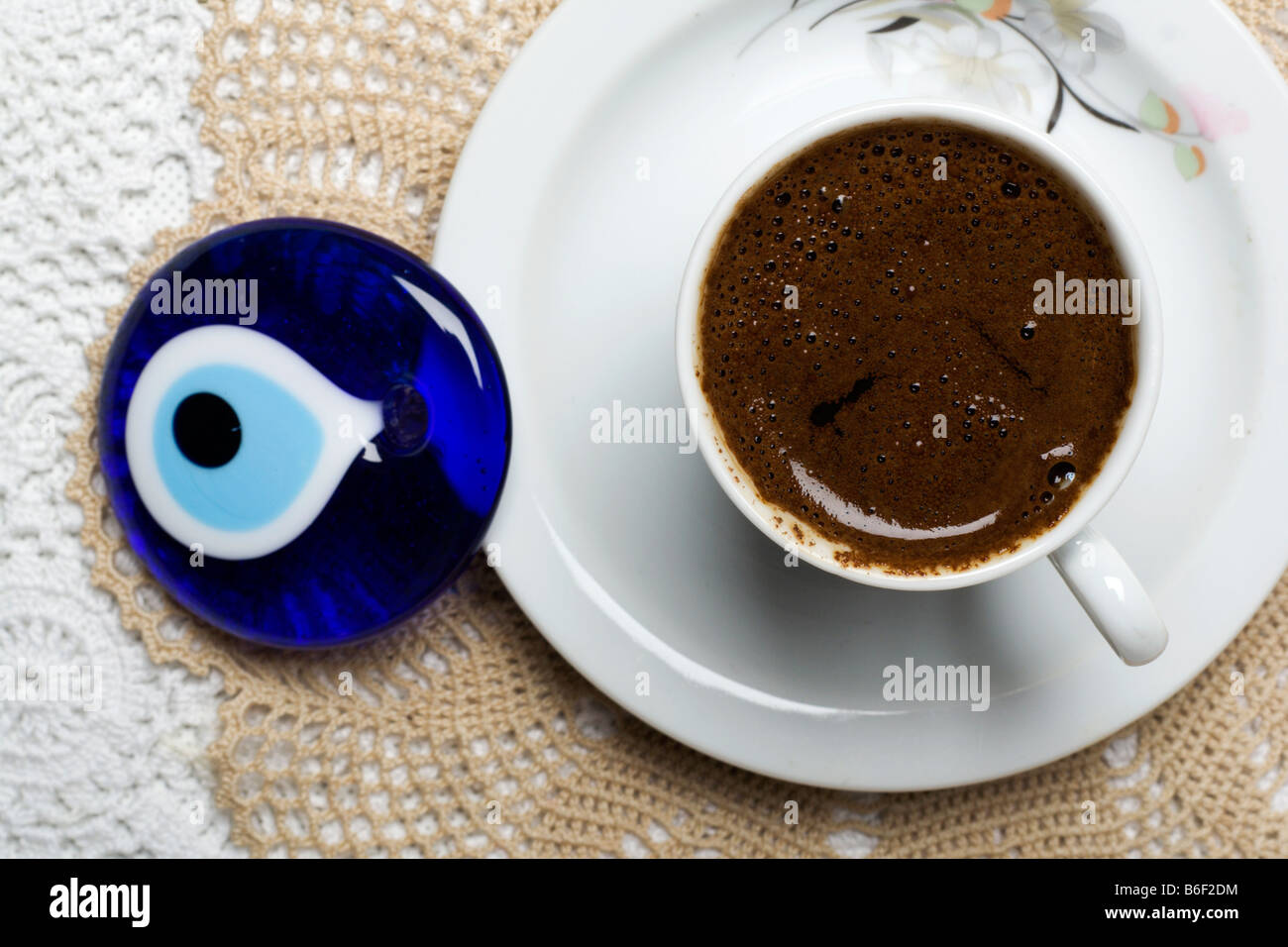 Il caffè turco e blue eye che è uno dei simboli della Turchia collocato sul tavolo con tovaglia di pizzo Foto Stock