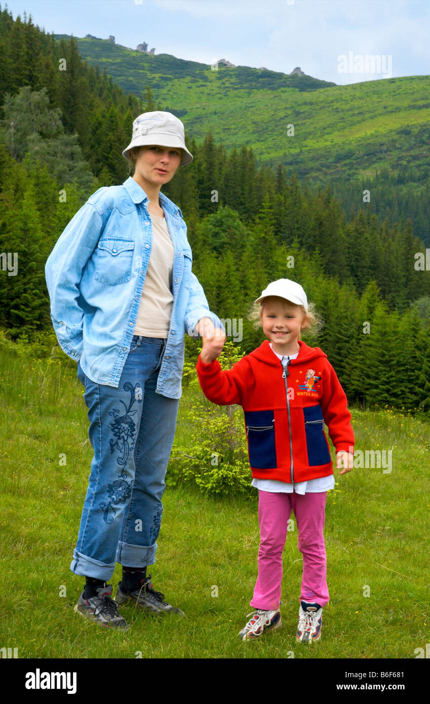 Madre con piccola ragazza su sfondo di montagna Foto Stock
