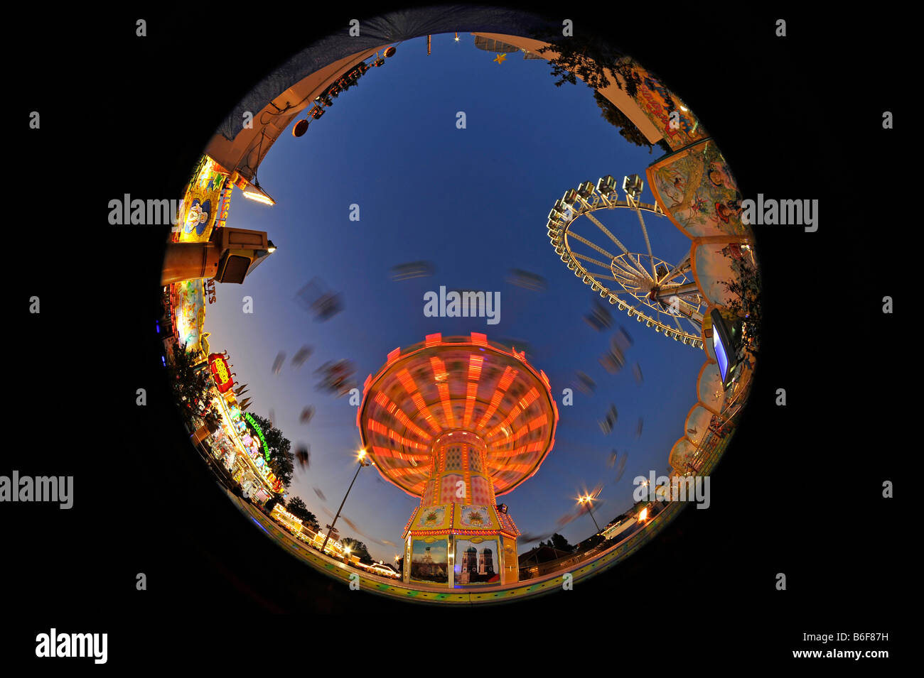 Chairoplane e ruota panoramica Ferris attraverso una lente fish-eye, night shot, al Cannstatter Volksfest Fiera di Stoccarda, Baden-Wuertte Foto Stock