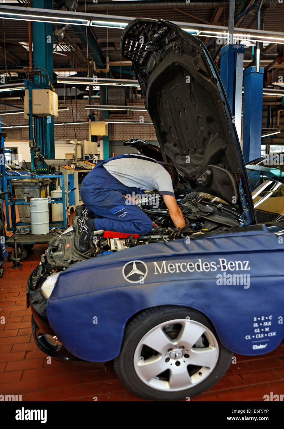 Mechanic inginocchiato sul blocco motore di una classe S Mercedes in auto  officina della Daimler AG, Mercedes Benz impianto Stutt Foto stock - Alamy