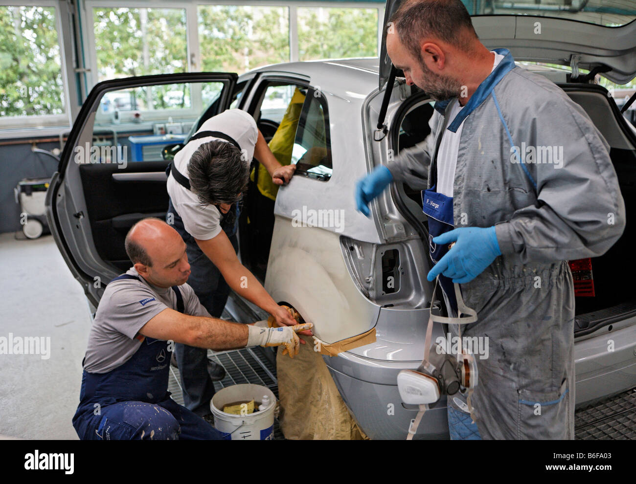 Auto paint specialisti di verniciatura di un pannello per auto in Paint shop della Daimler AG, Mercedes Benz impianto in Stoccarda, Boeblingen S Foto Stock