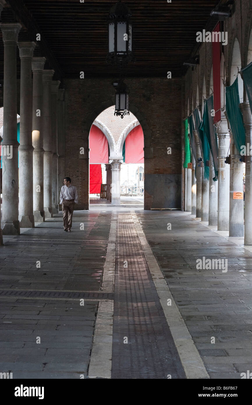 Uomo che cammina attraverso un passaggio pedonale porticato a Venezia, Italia e Europa Foto Stock