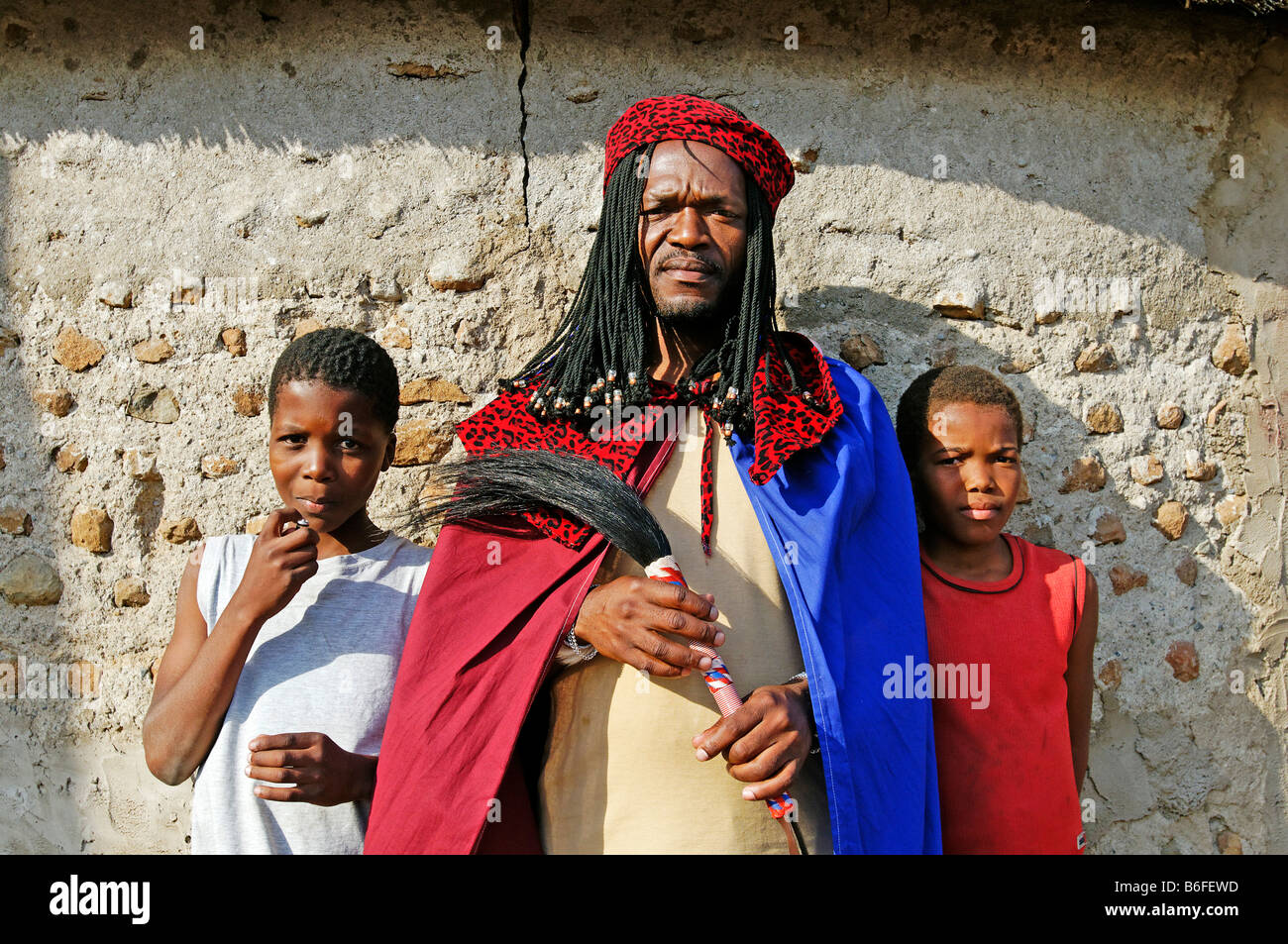Sangoma o sciamano o guaritore tradizionale del popolo Zulu, con i suoi due figli, Kwazulu-Natal, Sud Africa Foto Stock