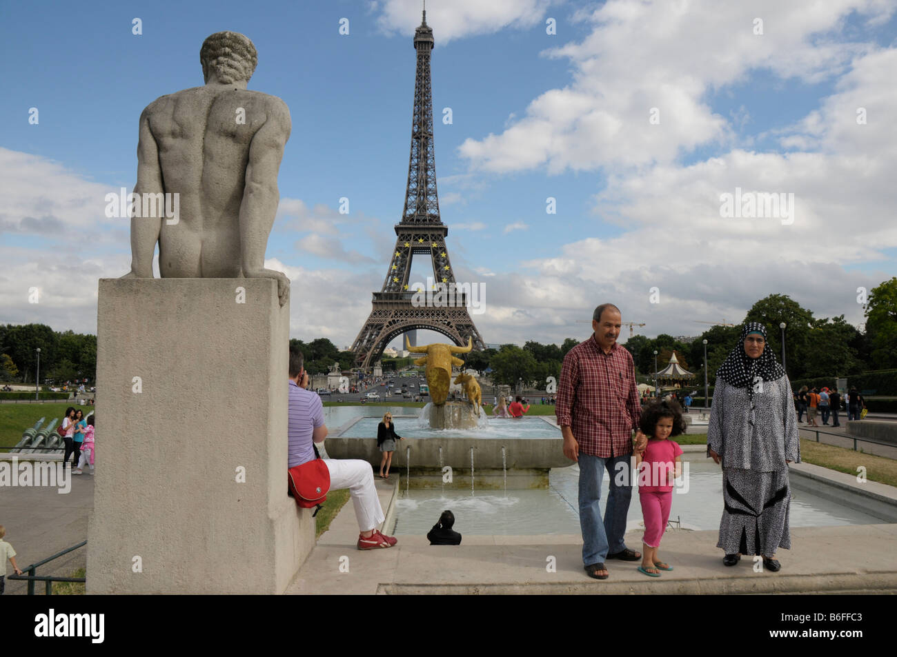 Famiglia immigrata in posa davanti alla Torre Eiffel, Parigi, Francia, Europa Foto Stock