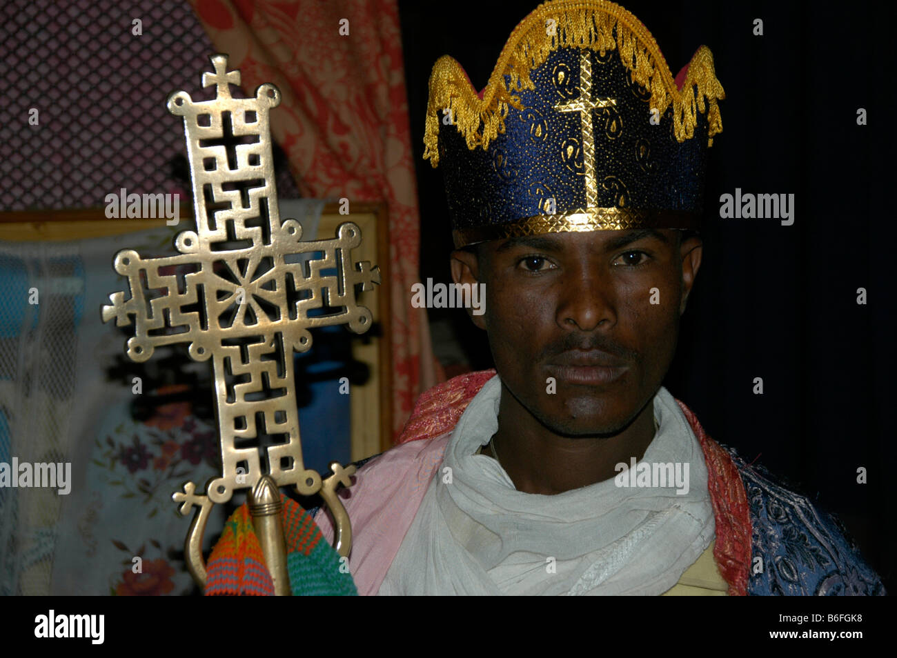 Sacerdote che indossa un copricapo e trattenere un abilmente decorate