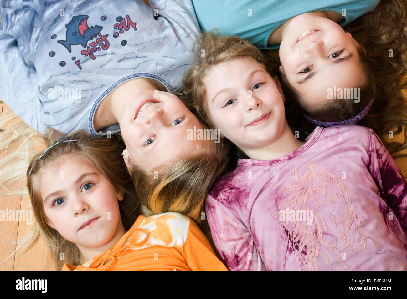Il gruppo di quattro ragazzine sdraiato sul pavimento, da sinistra 6, 11, 9 e 10 anni, Vista panoramica Foto Stock