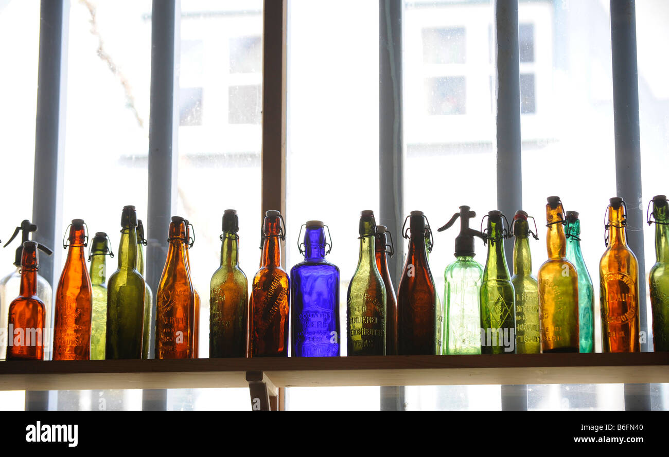 Bottiglie colorate su un ripiano Foto Stock