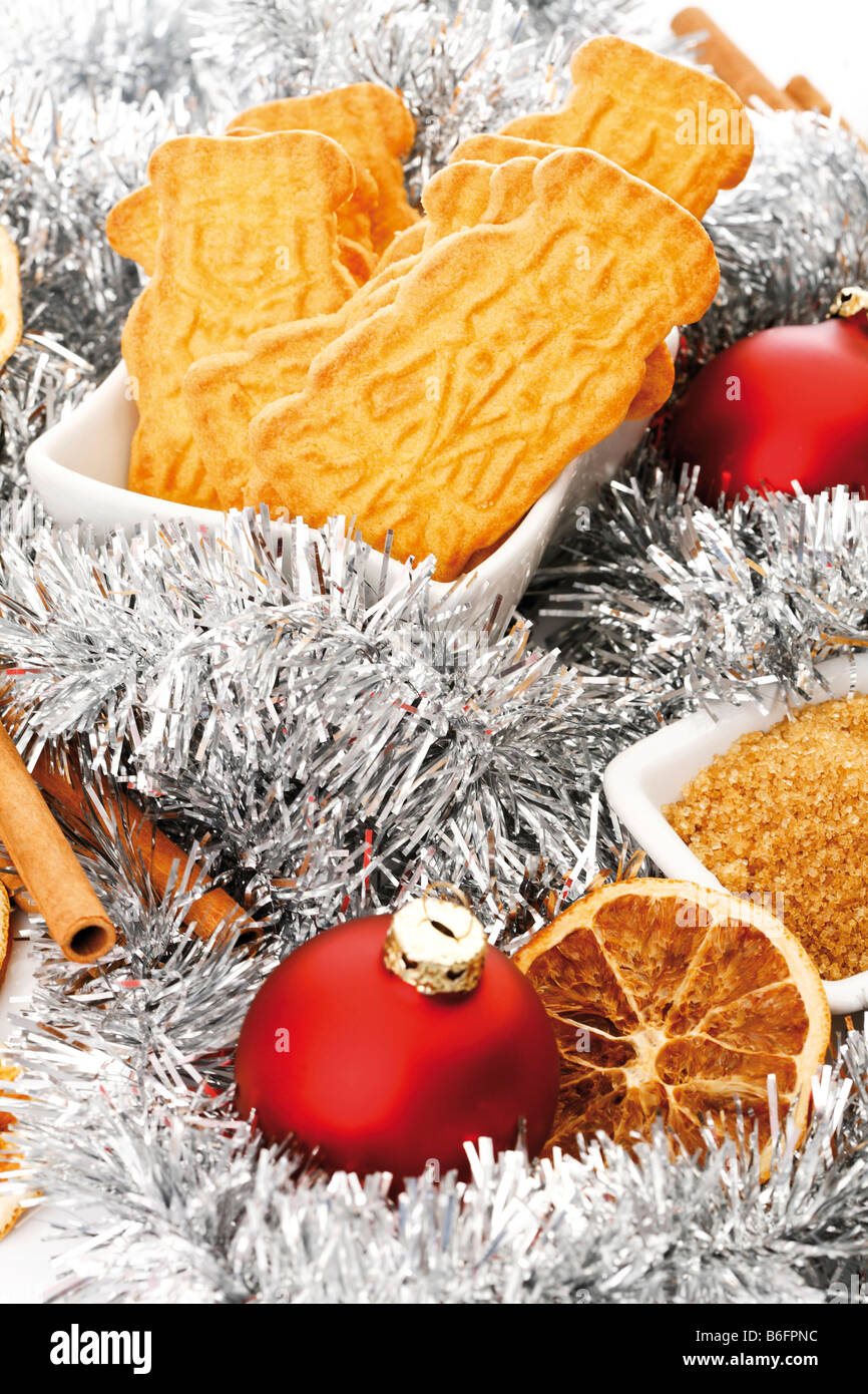 I biscotti speziati in una ciotola bianco e decorazioni di Natale, bastoncini di cannella, fettine di arancia e di albero di natale sfere Foto Stock