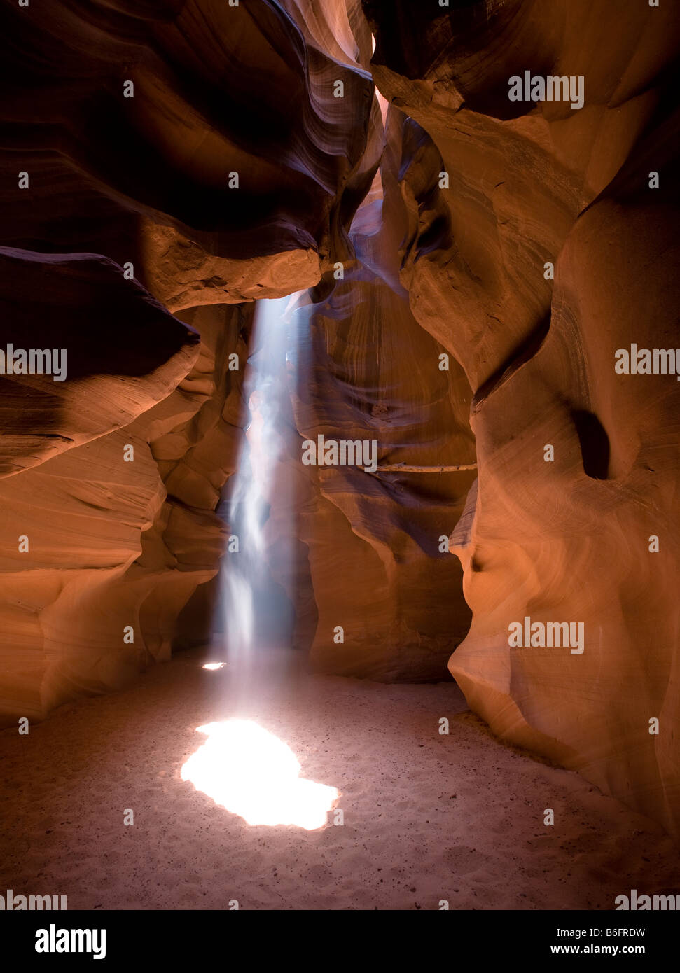 Il mezzogiorno sole proietta un fascio di sole sul pavimento delle formazioni di arenaria di superiore Antelope Canyon, Page Arizona Foto Stock